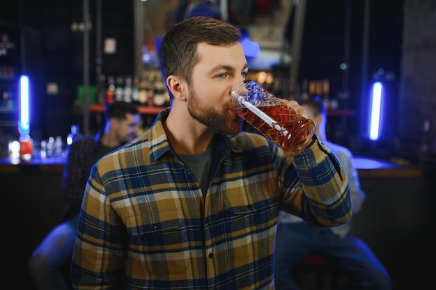 Degustando una buena cerveza Retrato de hombres pensativos bebiendo cerveza en el bar