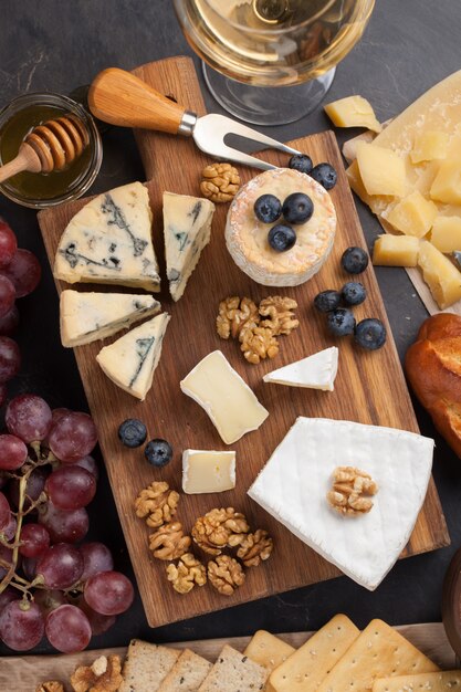 Degustando un plato de queso en un plato de piedra oscura.