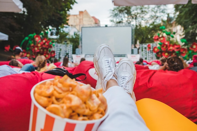 Deitado comendo lanches assistindo filme no cinema ao ar livre