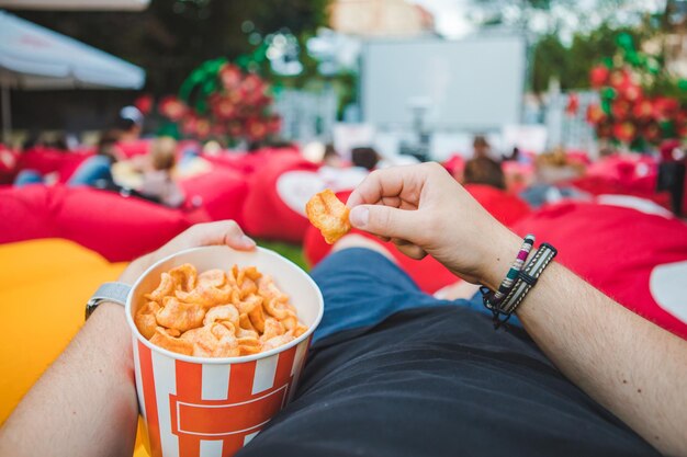 Deitado comendo lanches assistindo filme no cinema ao ar livre