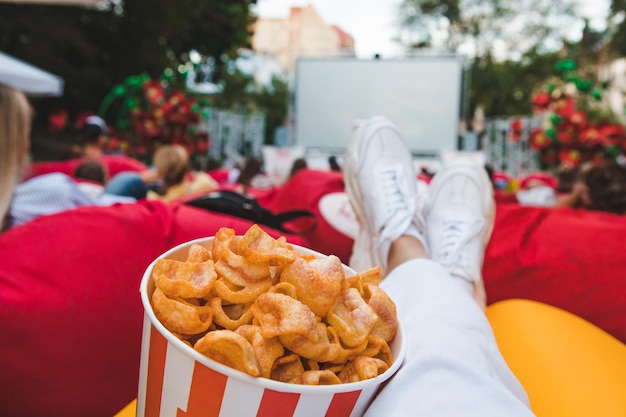 Deitado comendo lanches assistindo filme no cinema ao ar livre