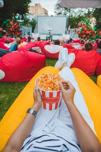 Deitado comendo lanches assistindo filme no cinema ao ar livre