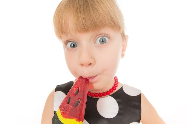 Deixe-me ver. Closeup retrato fisheye de uma menina engraçada comendo pirulito de melancia isolado no branco