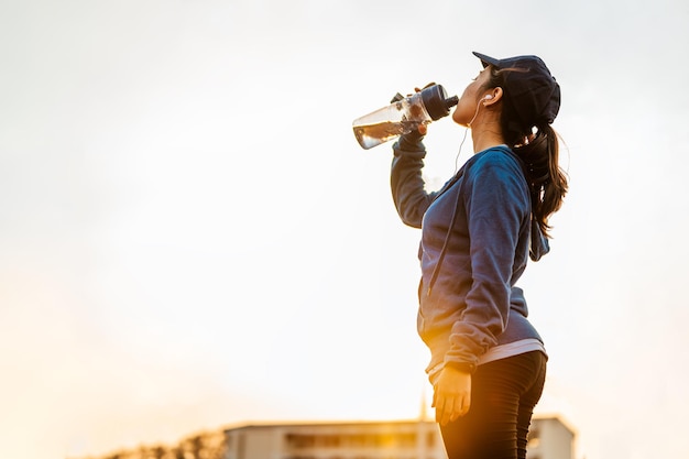 Deja de descansar y bebe proteína de suero después de correr trotar en la pista de atletismo