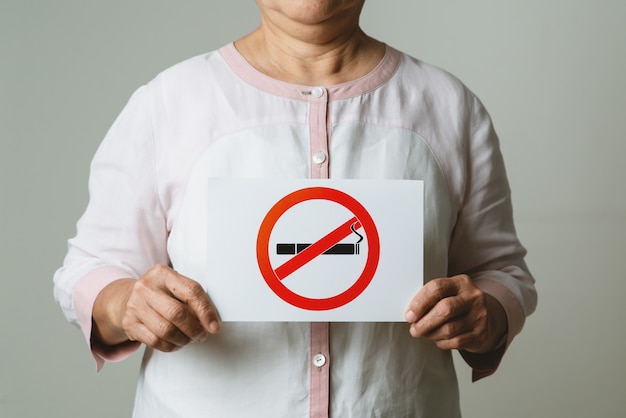 Foto dejar de fumar, día sin tabaco, madre con cartel de no fumar