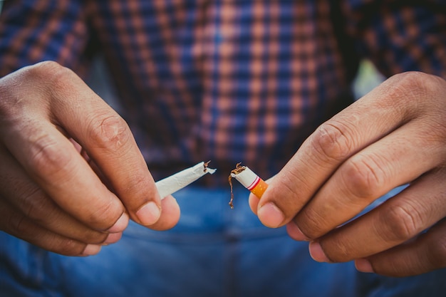 Dejar de fumar, manos humanas rompiendo el cigarrillo.