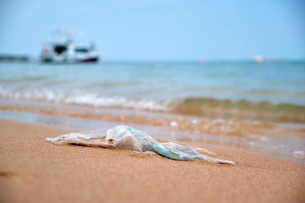 Dejó atrás la basura de la bolsa de plástico en la playa de arena Basura sucia usada vacía en la orilla del mar Contaminación ambiental Problema ecológico