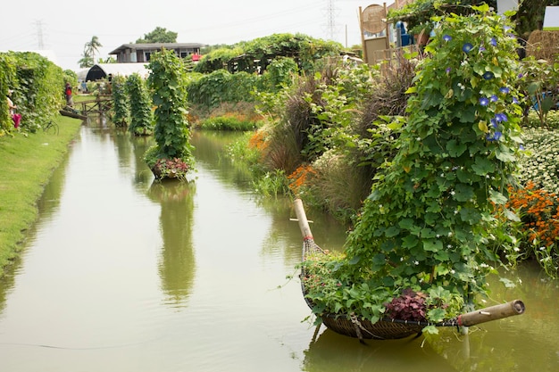 Dekoration Bambusboot und Baumpflanze im Kanal für Reisende, die das Gemüse- und Pflanzenfestival in Nonthaburi Thailand besuchen und fotografieren