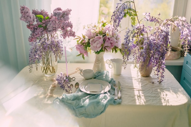 Dekoration der festlichen Tafel mit Blumen in zarten Farben und hellen Tönen