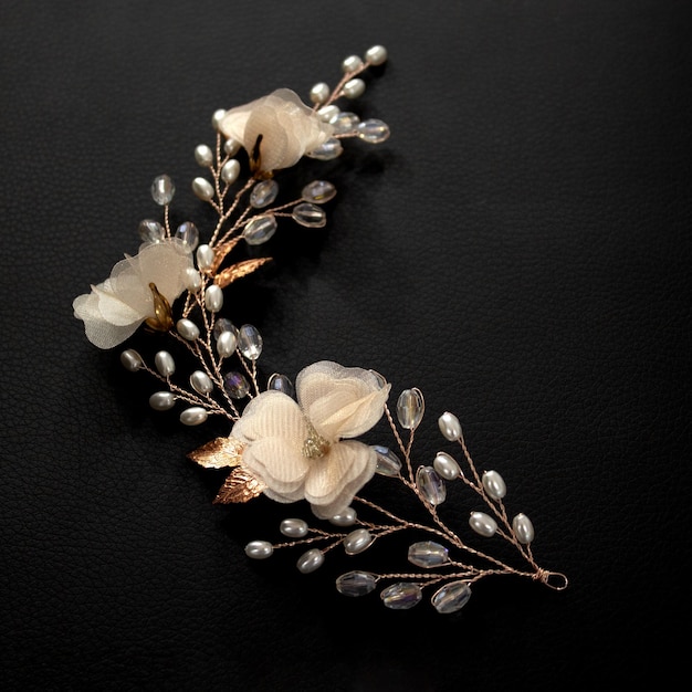 Dekoration eines Zweiges für die Frisur einer Braut aus Glasperlen Schmuckdraht Hintergrund aus schwarzer weicher Polsterung