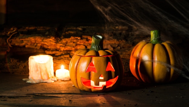 Dekoration für die Halloween Feier mit Kürbissen, Spinnen, Kerzen auf rustikalem Holz