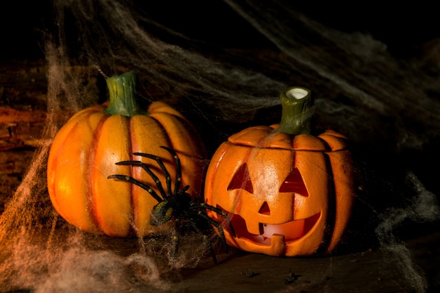 Dekoration für die Halloween Feier mit Kürbissen, Spinnen, Kerzen auf rustikalem Holz