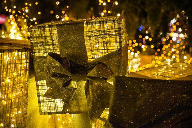Dekoration für Weihnachtsferien. goldene geschenkbox unter weihnachtsbaum am stadtplatzkonzept