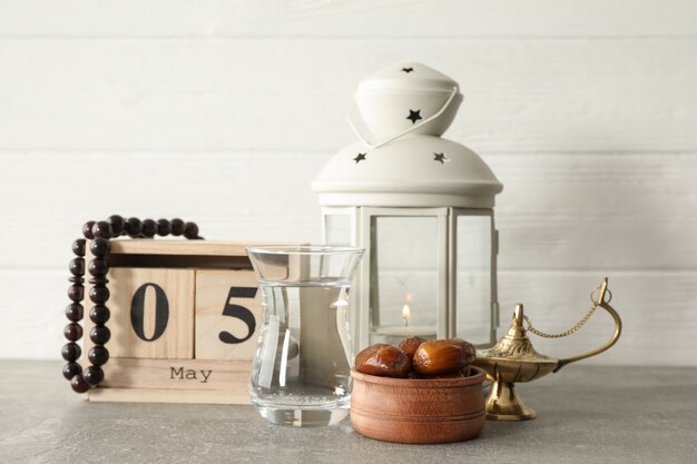 Dekoration und Essen mit Kalender auf grauem Tisch gegen hölzernen Hintergrund
