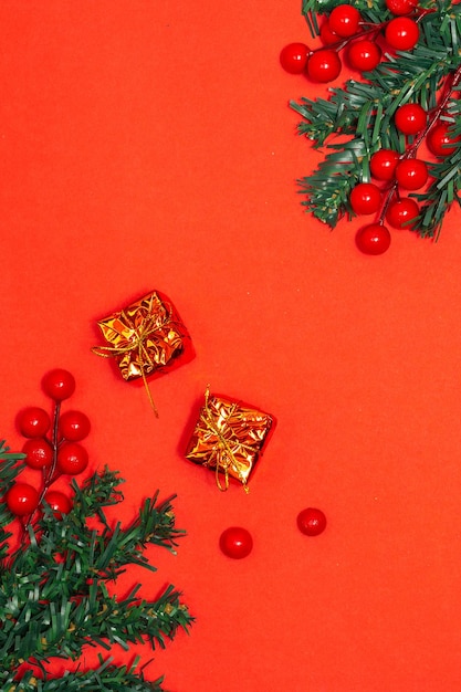 Dekoration Weihnachtskonzept Tannenzweige mit roten Beeren und goldenen Geschenkboxen