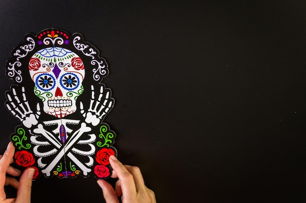 Dekorationen für den traditionellen mexikanischen Feiertag Tag der Toten auf schwarzem Hintergrund.