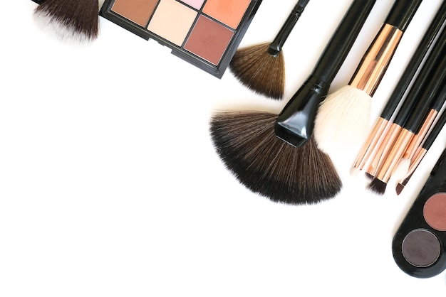 Dekorative Kosmetik- und Make-up-Pinsel auf einem weißen, isolierten Hintergrund, Draufsichtplatz für Ihren Text-Exemplarplatz das Konzept des Auftragens von Make-up visagiste