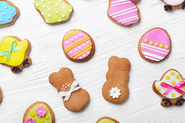 Foto dekorative lebkuchen-ostern-plätzchen auf weißem holzhintergrund