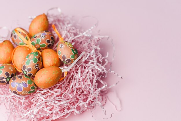 Dekorative orange kleine Eier auf einem rosa Papierfüller