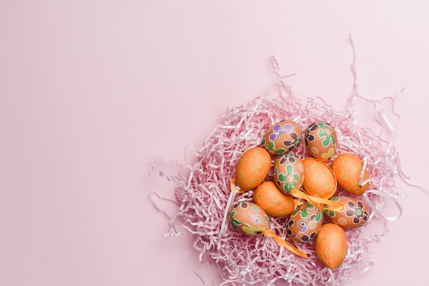 Dekorative orange kleine Eier in auf einem rosa Papierfüller und Hintergrund. Moderne Osterferienschablone
