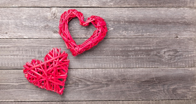 Dekorative rote Herzen auf grauem Holztisch. Valentinstag Grußkarte. Draufsicht. Speicherplatz kopieren