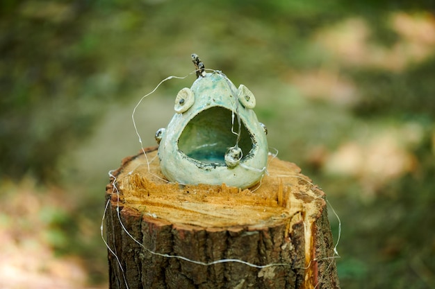 Dekorative Vasen, Kunstobjekte im maritimen Stil auf Baumstumpf bei einer Kunstausstellung im Freien im grünen Wald