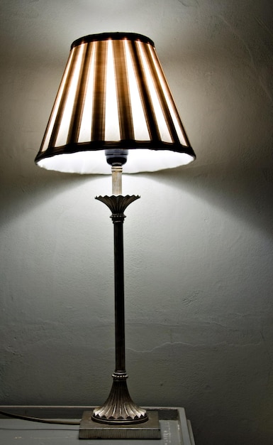 Foto dekorative vintage-lampe auf einem tisch mit eingeschaltetem licht.