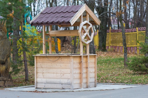 Dekorativer Holzbrunnen mit Dach im Park