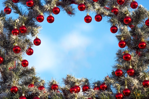 Dekorativer Rahmen von einem verzierten Weihnachtsbaum auf einem blauen Himmelhintergrund