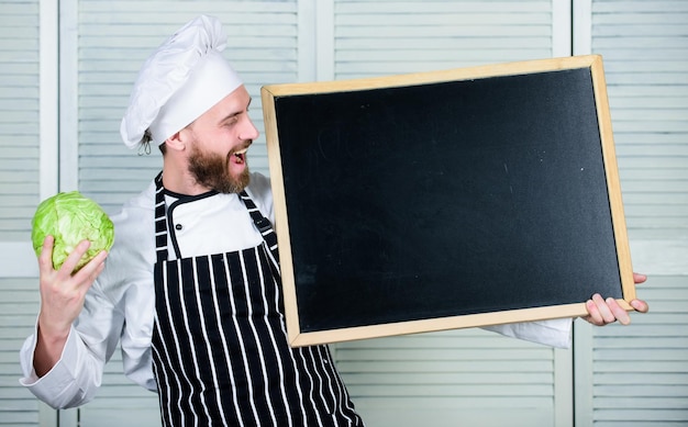 Delantal de sombrero de chef hombre sujetar espacio de copia de pizarra Concepto de receta Cocinar una comida deliciosa paso a paso Menú para hoy Lista de ingredientes para el plato de cocina Echa un vistazo a los consejos de cocina Consejos para cocinar como un profesional