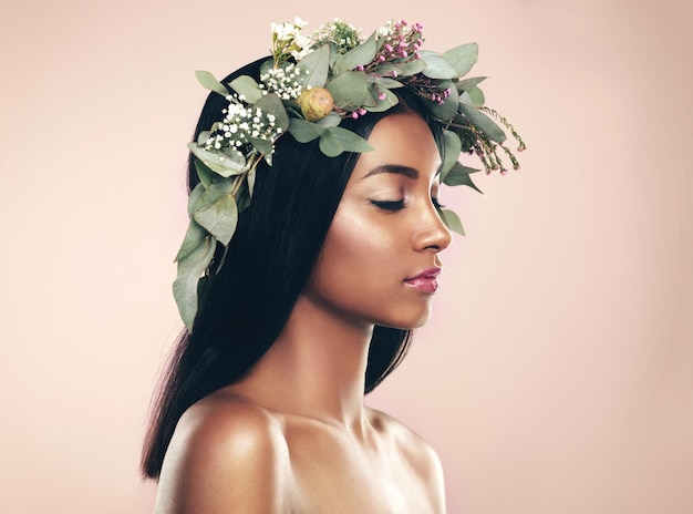 Deleitándose con la belleza natural Foto de estudio de una hermosa joven que lleva una corona mientras posa con los ojos cerrados sobre un fondo rosa