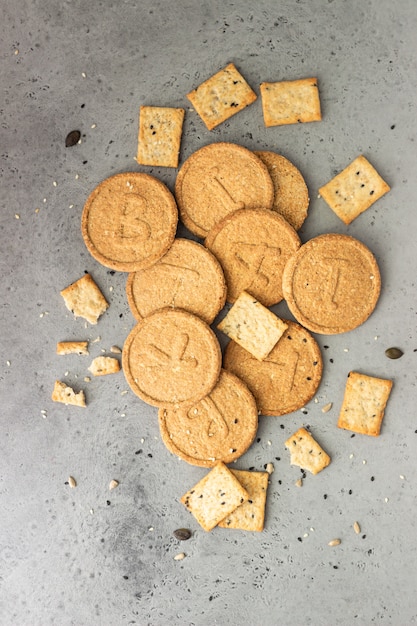 Delgado crujientes galletas integrales con semillas en hormigón gris.