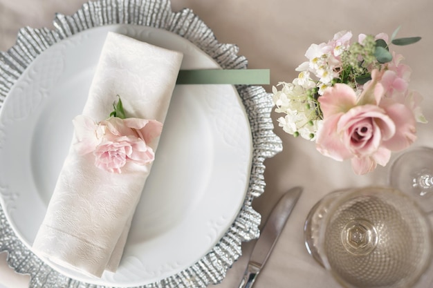 Delicada mesa de bodas Un plato con una servilleta y una rosa