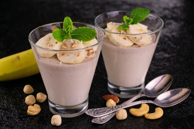 Delicada mousse de banana com nozes em um fundo preto Closeup