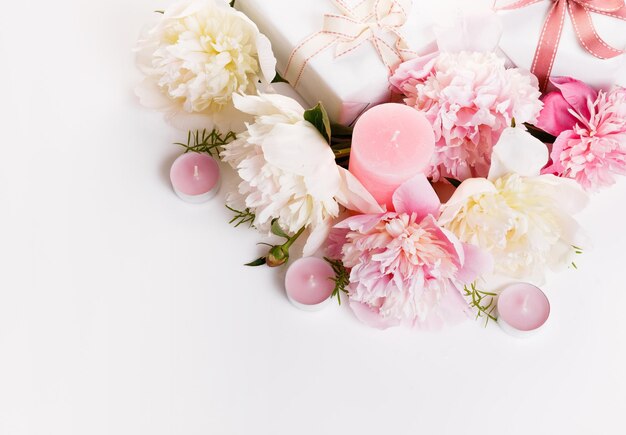 Delicada peonía rosa blanca con pétalos, flores y regalos, vela de listón blanco en pizarra blanca, Vista superior, endecha plana, Espacio de copia, Cumpleaños, Madres, San Valentín, Mujeres, Día de la boda, concepto