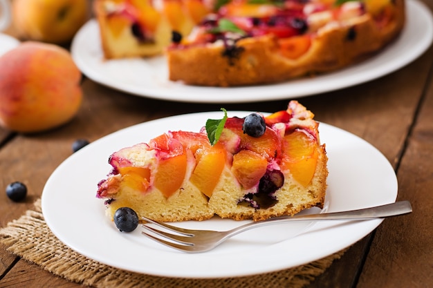 Delicada tarta de galletas con melocotones y arándanos.