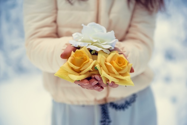 Delicadas flores en manos de una niña en invierno.