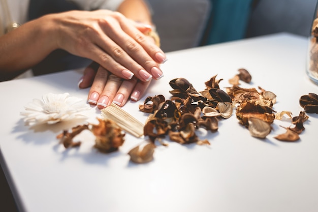 Delicadas mãos femininas com uma bela manicure francesa.