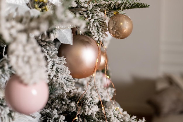 Delicado árbol de Navidad blanco y adornos navideños, bolas y cintas, guirnaldas y luces, rosa, perla, perla, color pastel, tarjeta de felicitación de año nuevo, feliz Navidad.