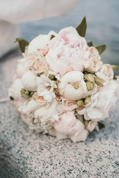 Delicado bouquet de noiva com peônias e rosas. Buquê de casamento em close-up