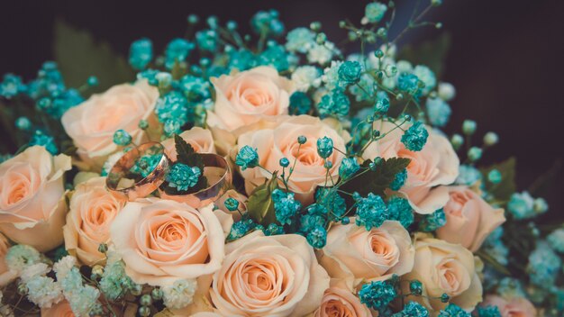 Delicado bouquet de noiva romântico de rosas pêssego com anéis de casamento