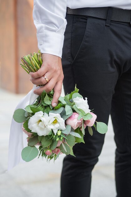 Delicado buquê de casamento nas mãos do noivo ideia para agências de eventos