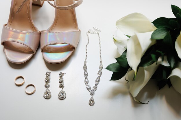 El delicado ramo de joyas brillantes de la novia complementa perfectamente sus elegantes zapatos de novia y anillos radiantes accesorio de boda