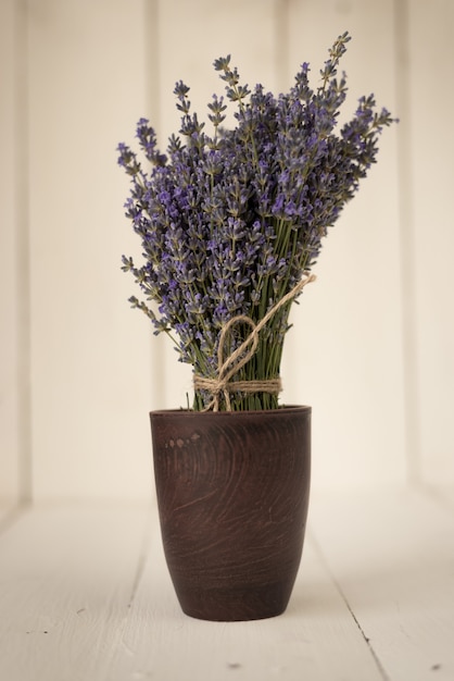 Delicado ramo púrpura de flores de lavanda en un vaso de madera vintage con olor a Provenza francesa.