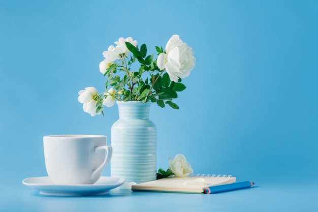 Delicado ramo de rosas silvestres y una taza de té