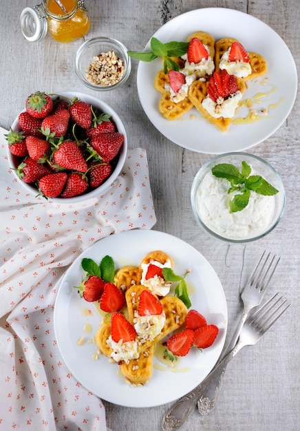 Delicados y deliciosos gofres belgas derretidos con crema batida, fresas, aromatizados con maní y miel.