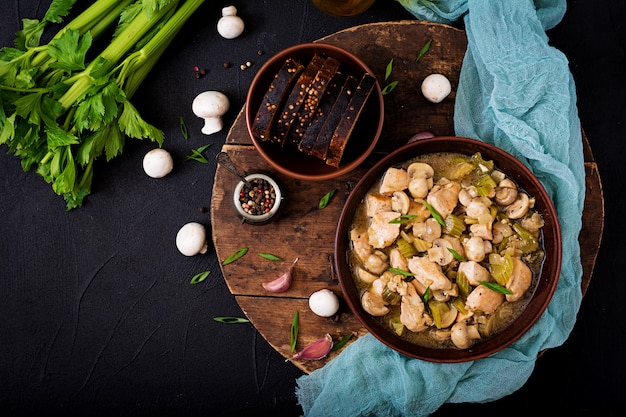 Delicados pedaços de filé de frango com cogumelos e aipo cozidos em cerveja light. postura plana. vista do topo