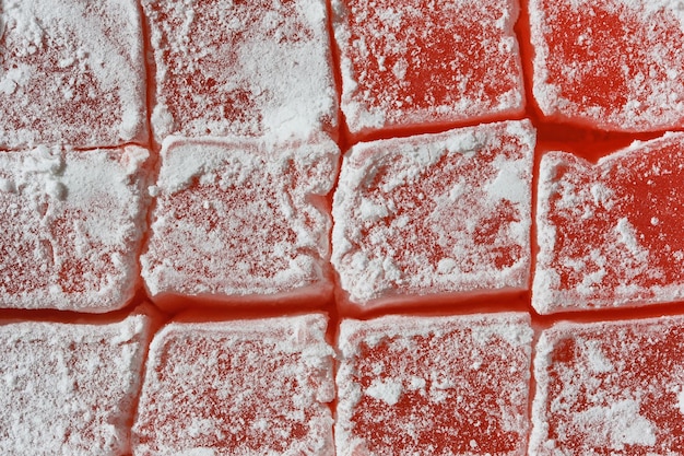 Delícia turca vermelha com fundo de textura closeup de açúcar em pó