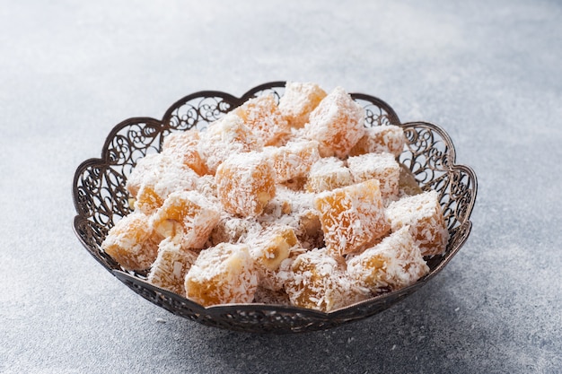 Delicias turcas con avellana en un recipiente de metal tallado.