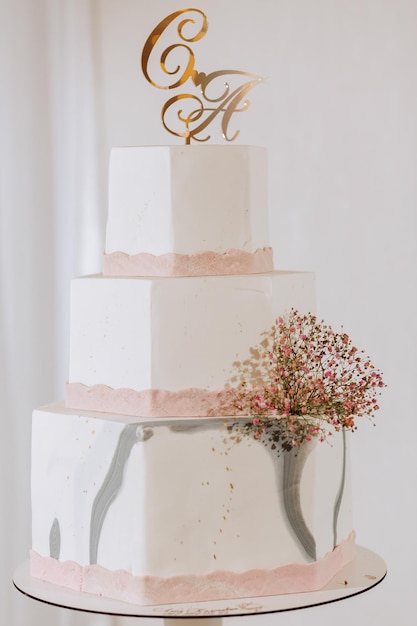 Una deliciosa boda pastel rosado de tres niveles decorado con flores barra de dulces para un banquete concepto de celebración postres de moda mesa con dulces dulces frutas